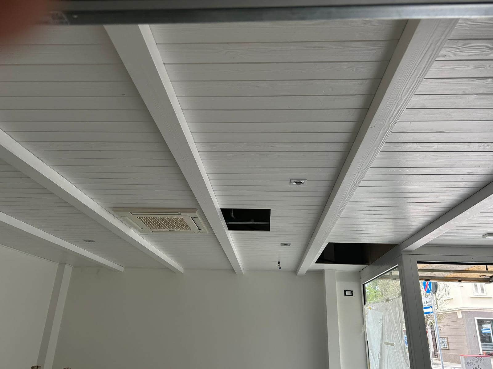 Un soffitto bianco con un buco in una stanza.