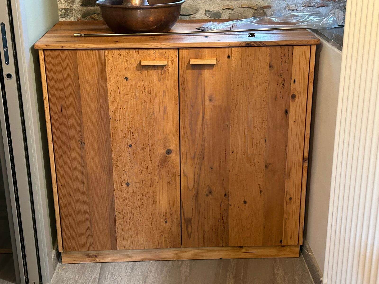 Un mobiletto di legno con una ciotola sopra