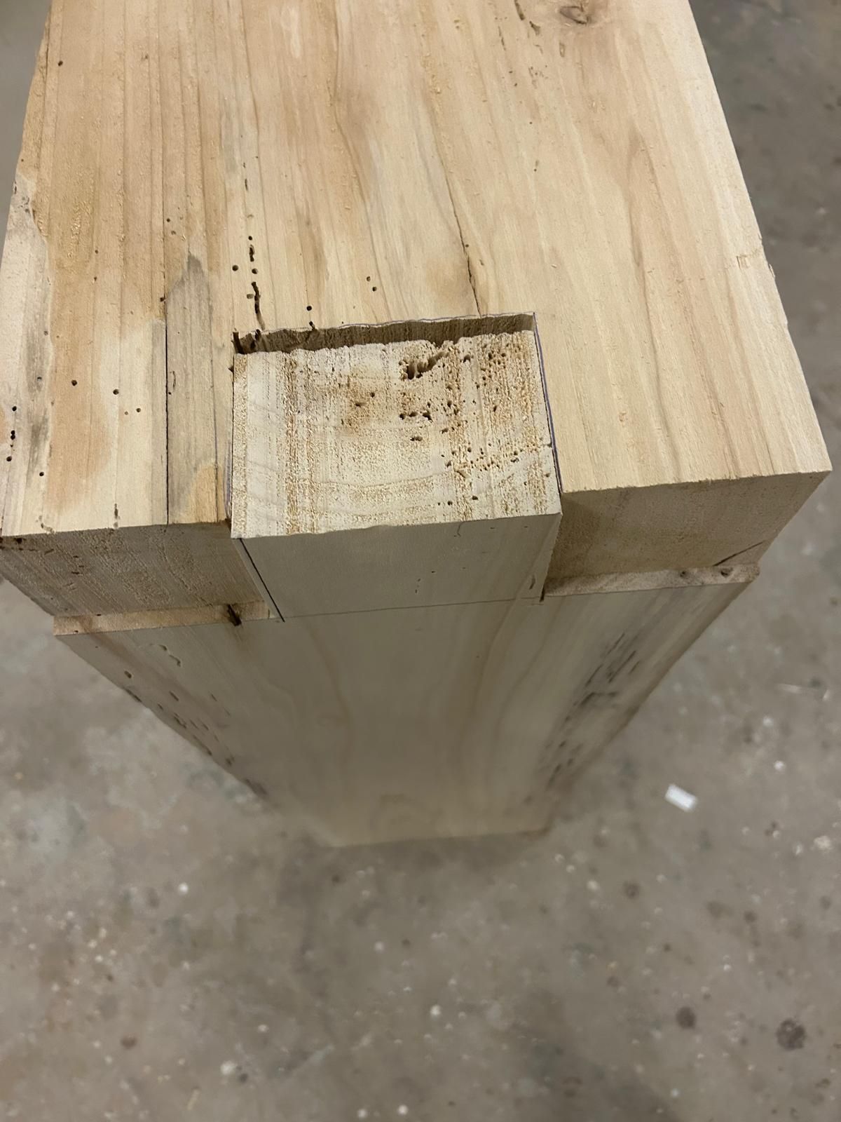 Un pezzo di legno con un buco è appoggiato sul pavimento.