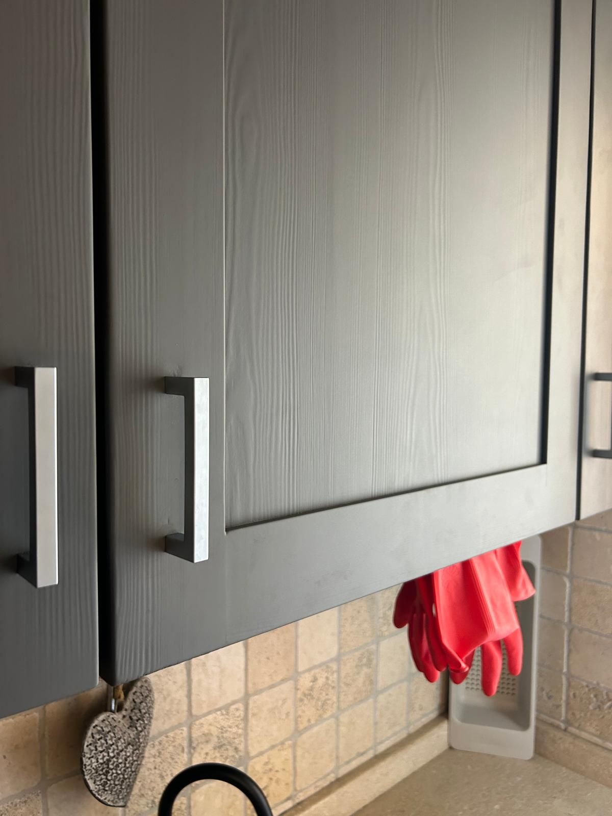 Un guanto rosso è appeso a un mobile in cucina.
