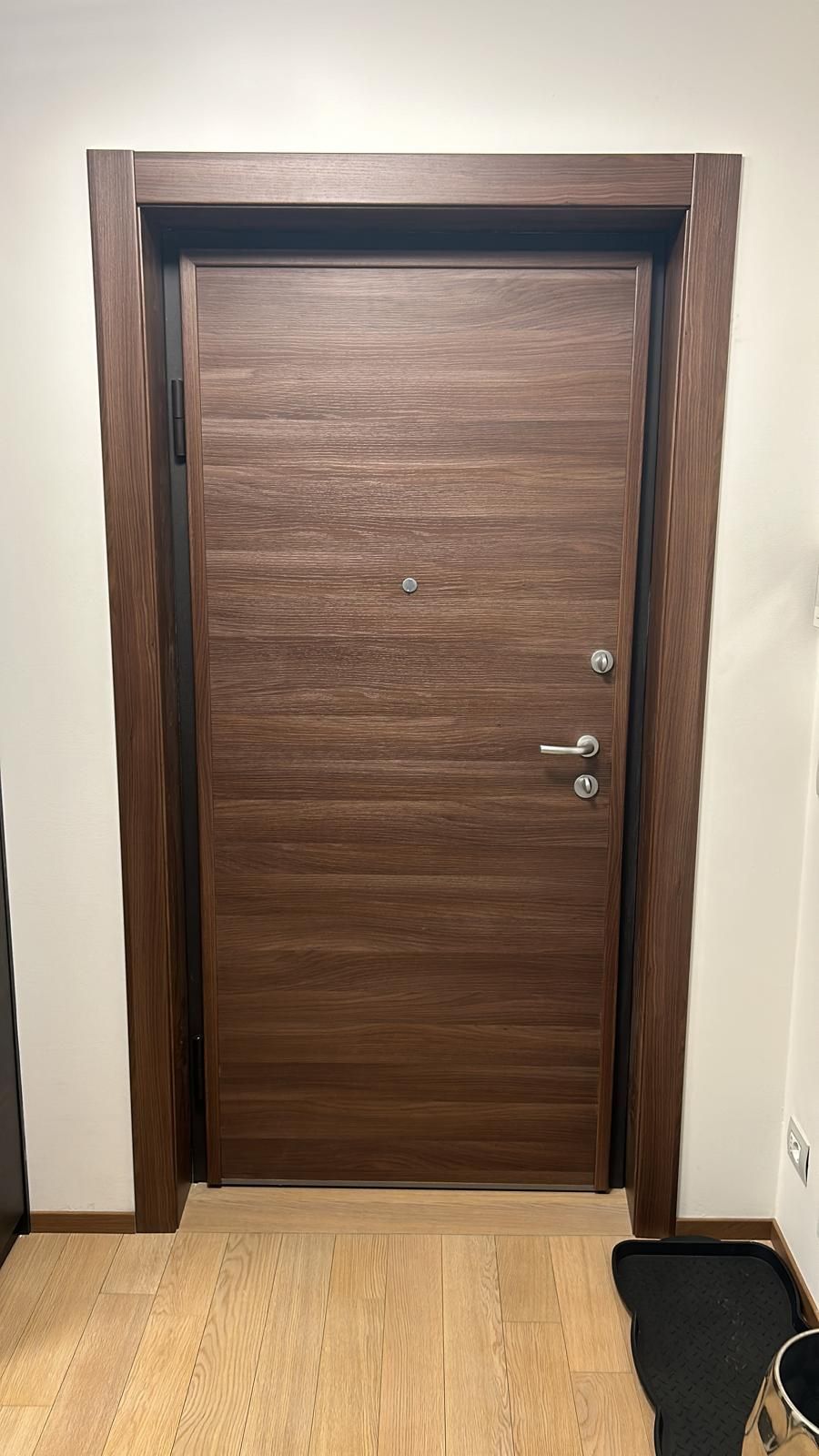 Una porta di legno è appoggiata su un pavimento di legno in una stanza.