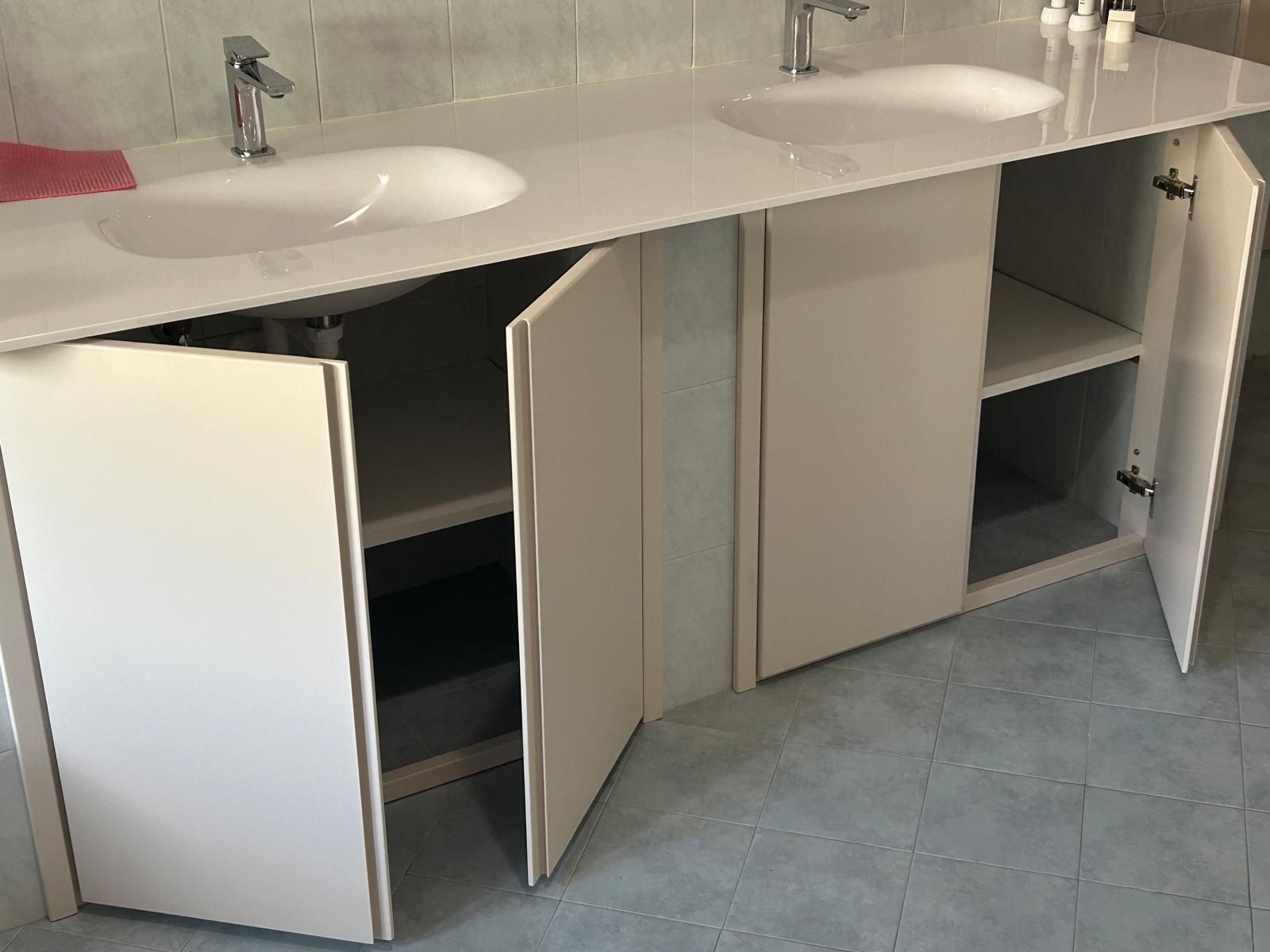 Un mobiletto del bagno con due lavandini e due ante aperte