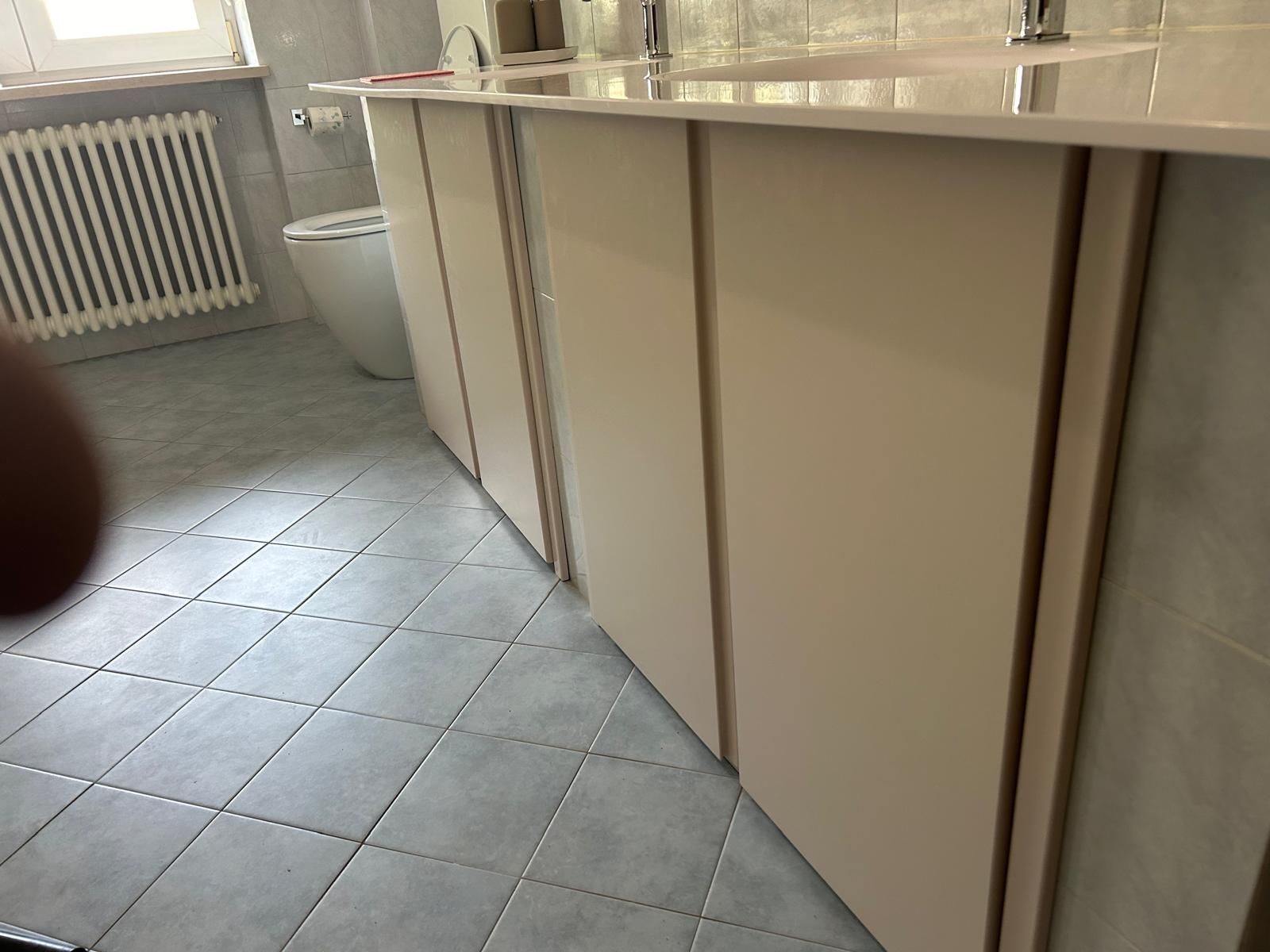 Un bagno con lavandino, water e termosifone.