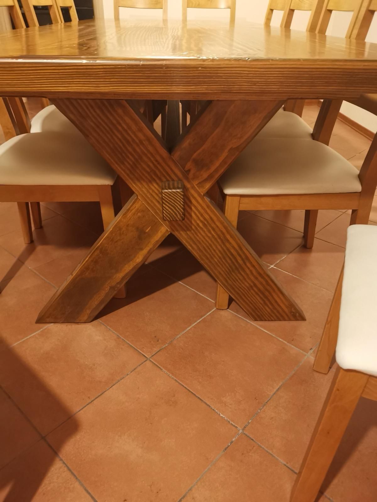 Un tavolo da pranzo in legno e sedie sono su un pavimento piastrellato