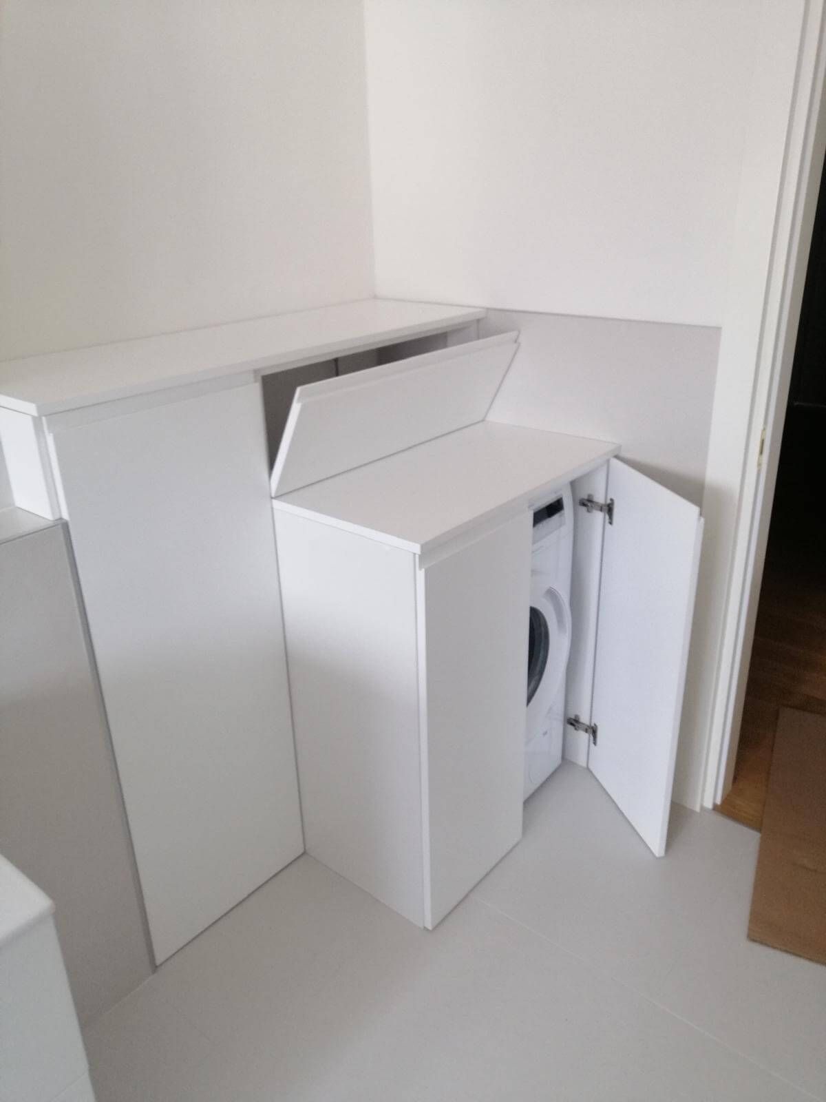 Un mobile bianco con una lavatrice al suo interno.