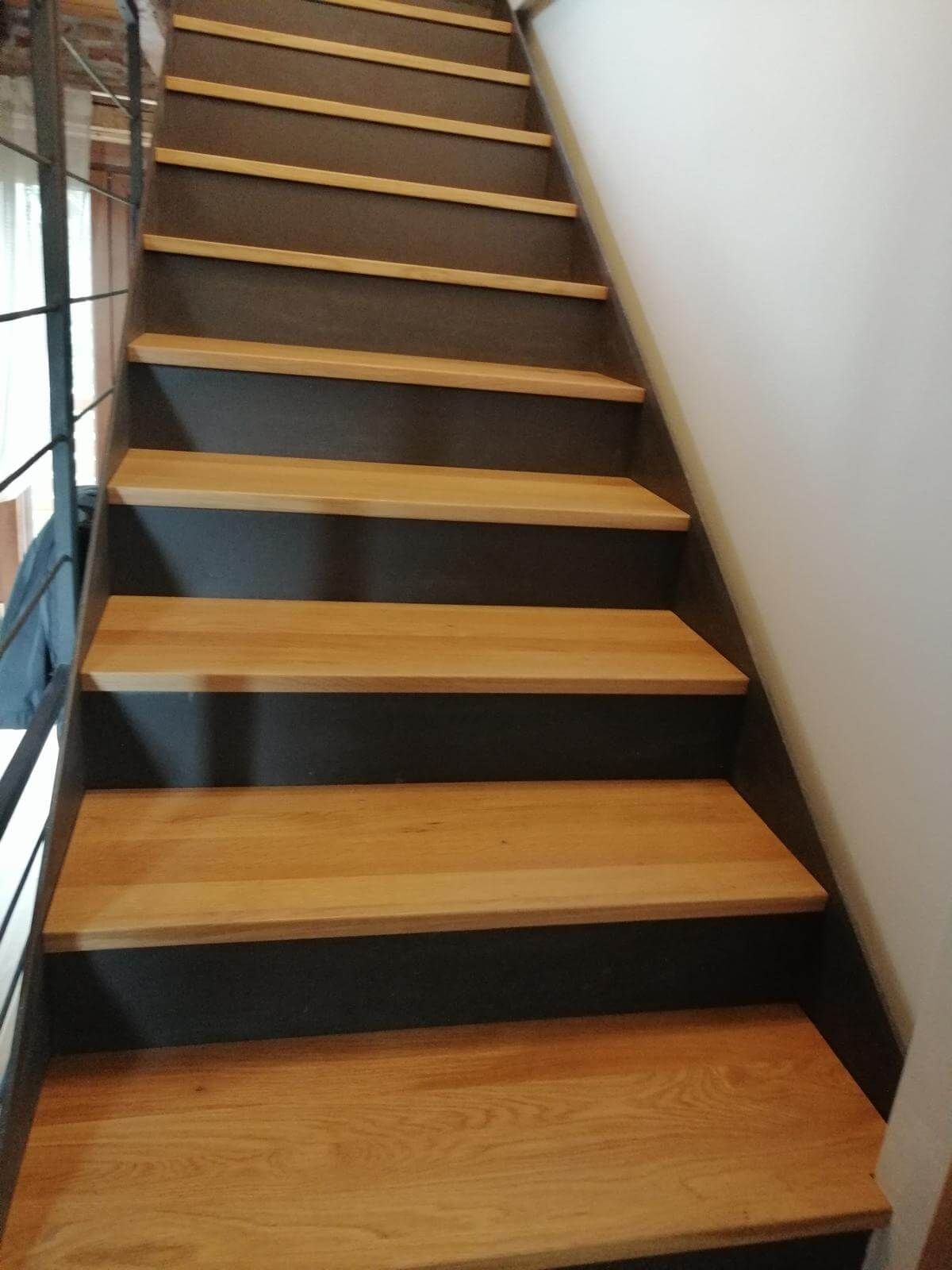 Una scala con gradini in legno e ringhiera in metallo