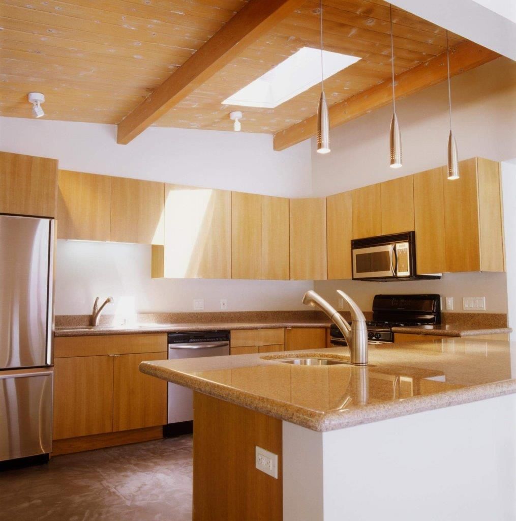 Una cucina con elettrodomestici in acciaio inox e mobili in legno