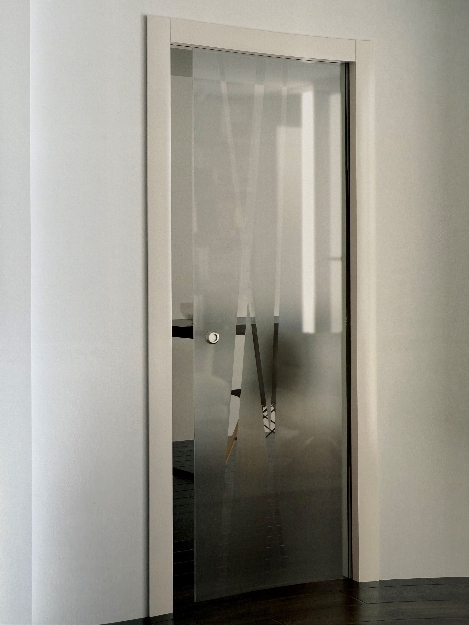 Una porta scorrevole in vetro in una stanza con pavimento in legno.