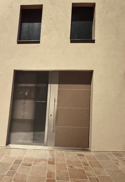 Un edificio con due finestre e una porta che sembra una faccina sorridente
