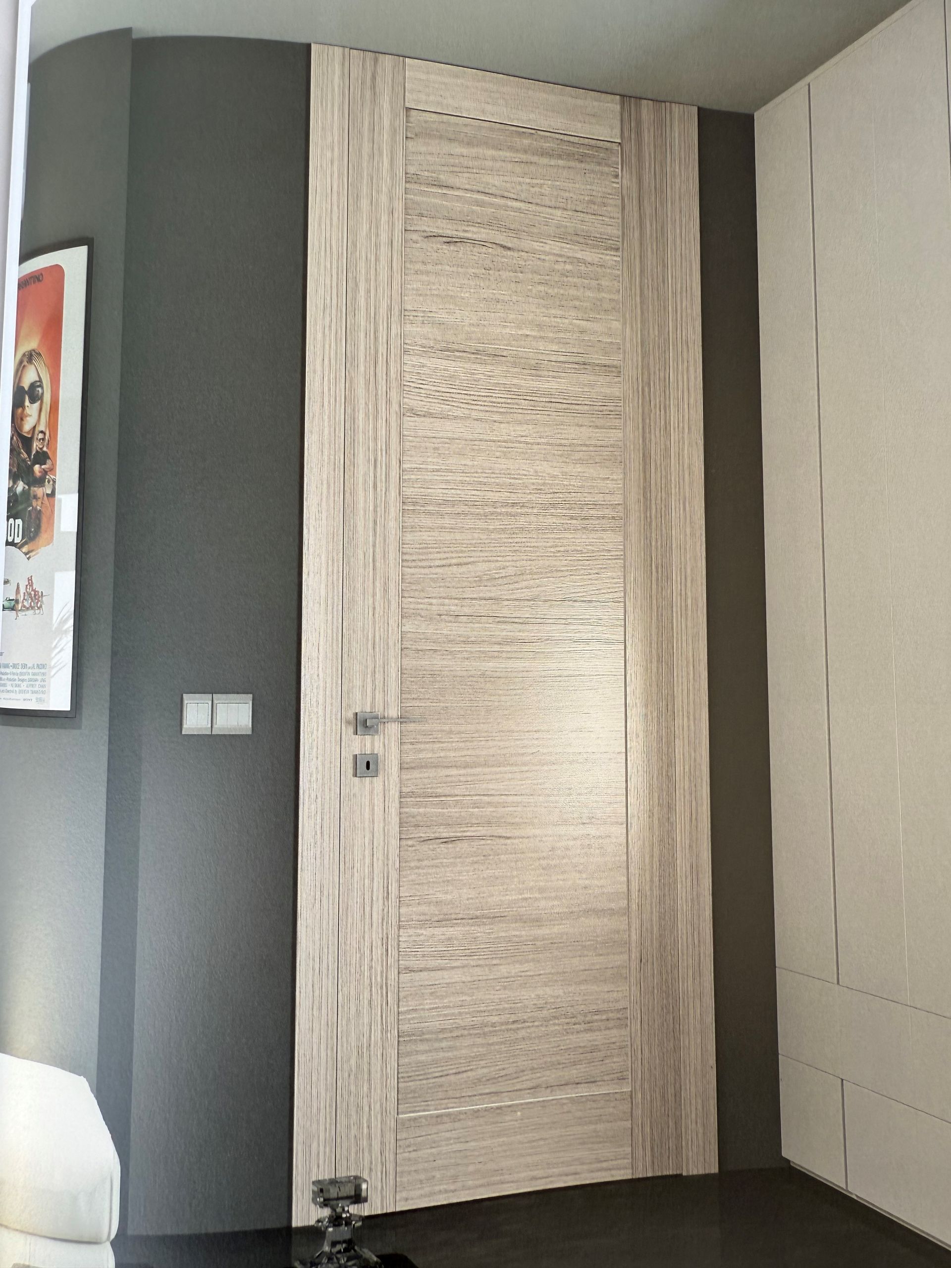 Una porta in una stanza con un poster sul muro sopra