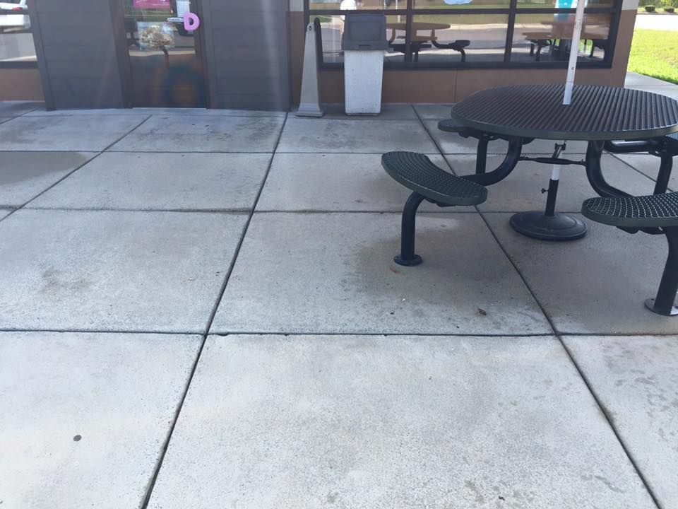 Outdoor seating area with a round table and attached benches on a concre