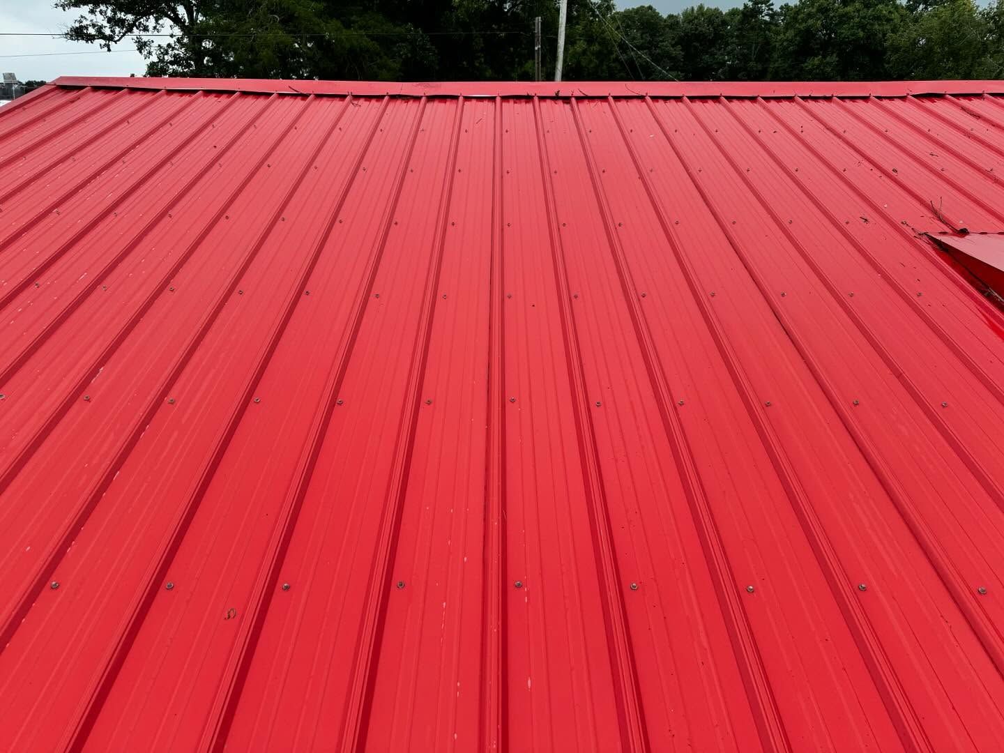 Red metal roof with vertical ridges, angled toward the top of the frame.