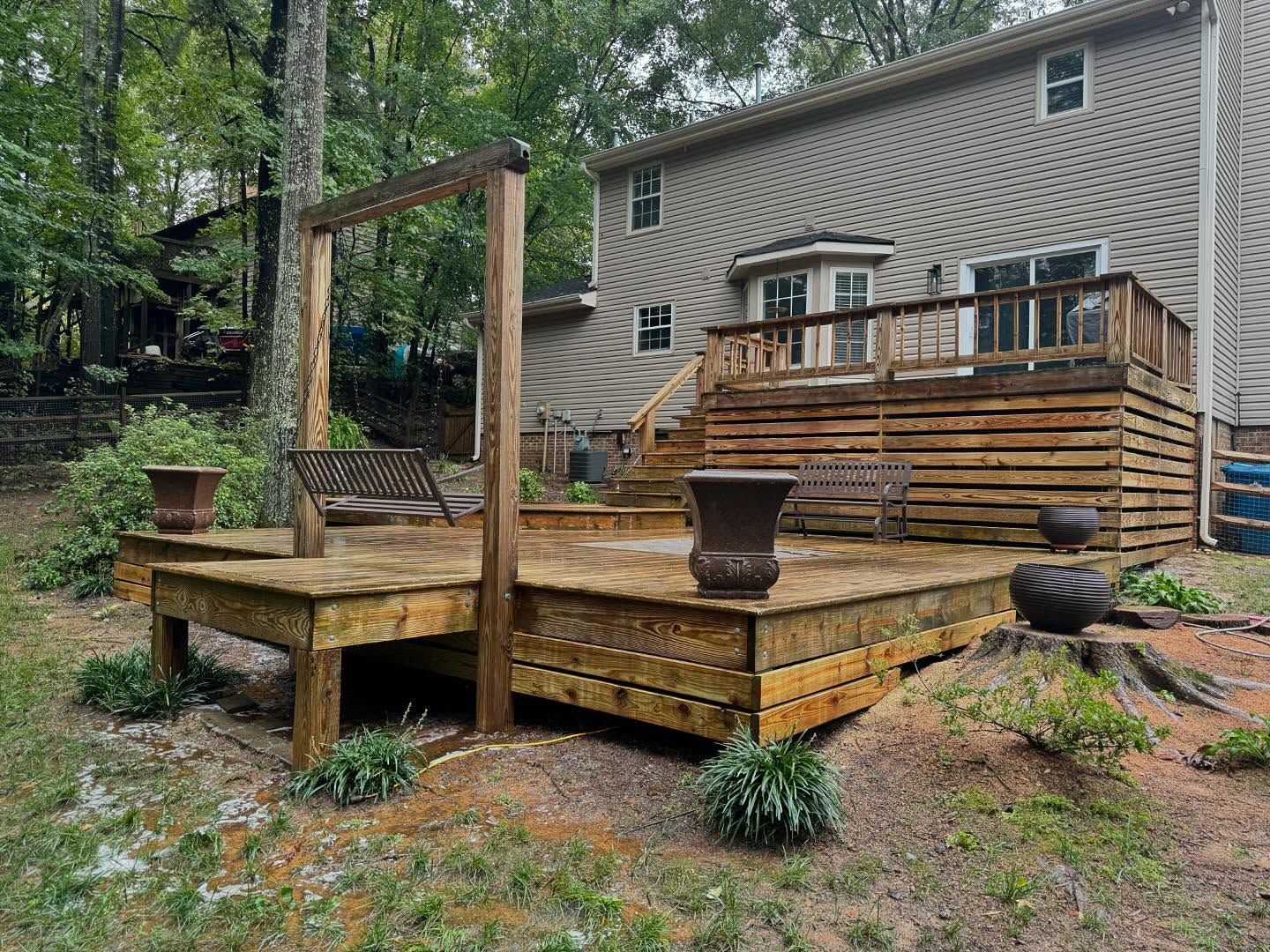 A wooden deck with a swing set in