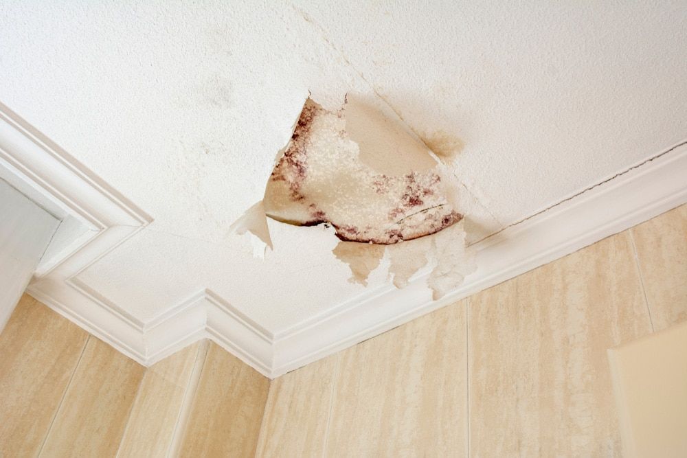 A Ceiling With Water Coming Out Of It And Peeling Wallpaper — Tweed Heads Leak Detection in Casuarina, NSW