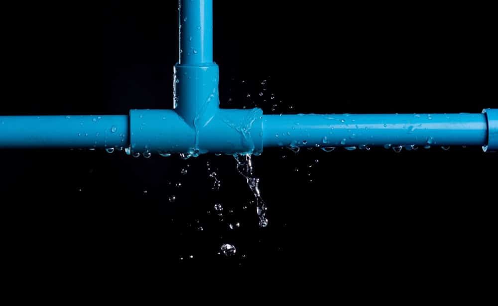 Water Is Leaking From A Blue Pipe On A Black Background — Tweed Heads Leak Detection in Casuarina, NSW