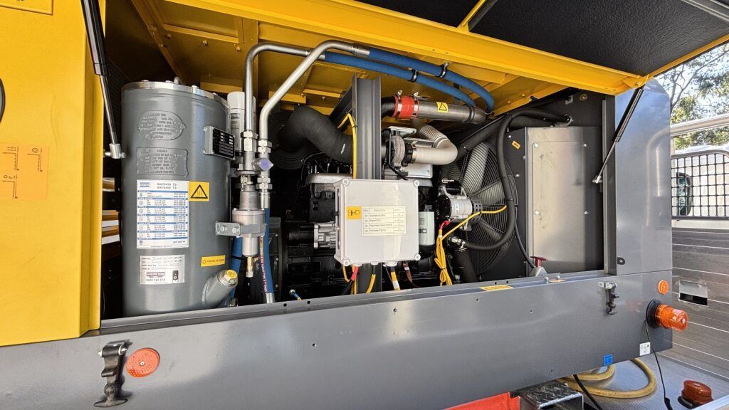 Two Men Are Cleaning a Manhole Cover With a High Pressure Washer — Tweed Heads Leak Detection in Casuarina, NSW