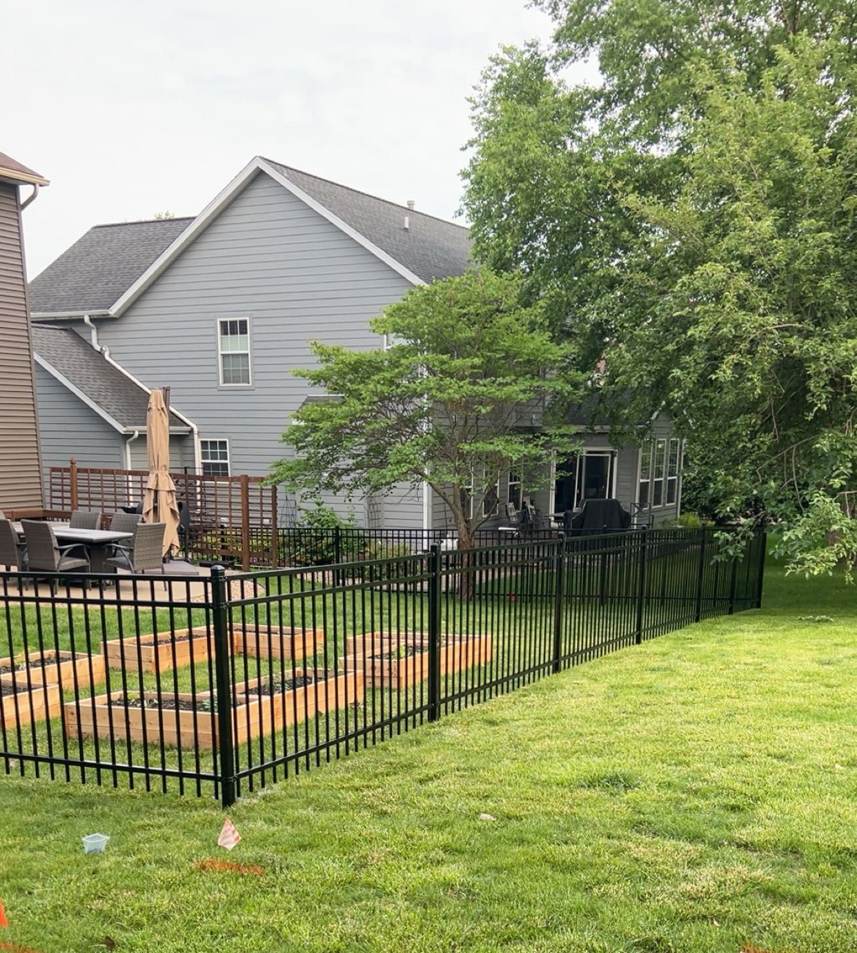 A wooden fence is sitting in the grass in front of a house.