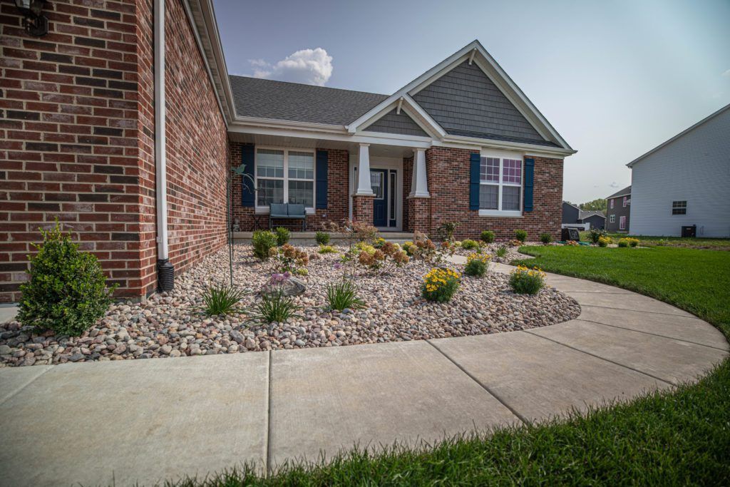 A brick house with a concrete walkway leading to it