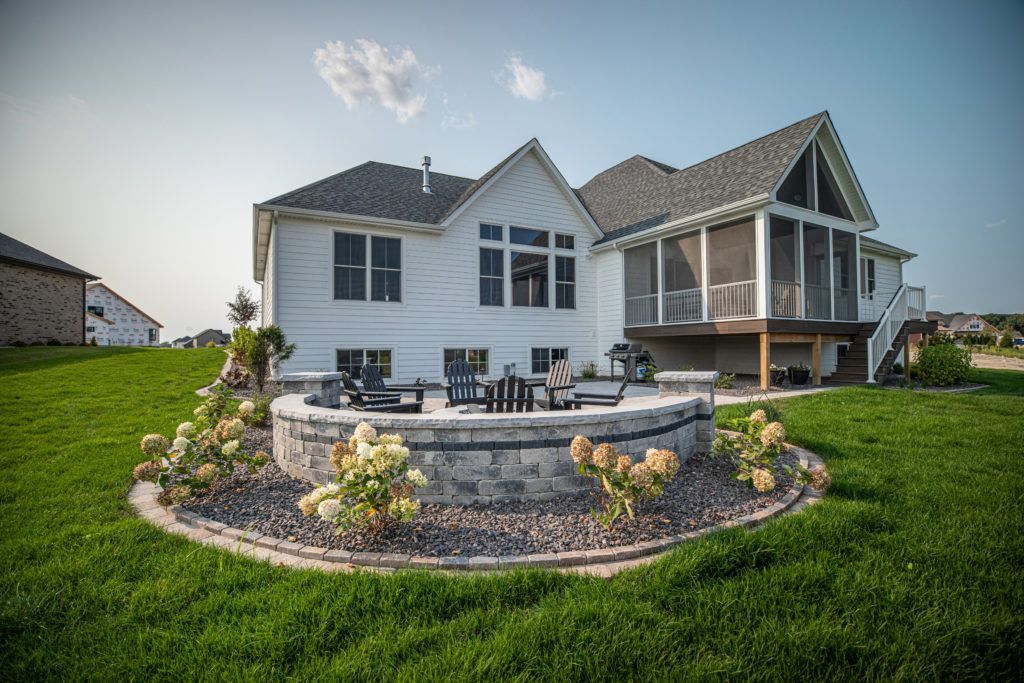 Outdoor living landscaping retaining wall and a fire pit in the backyard.