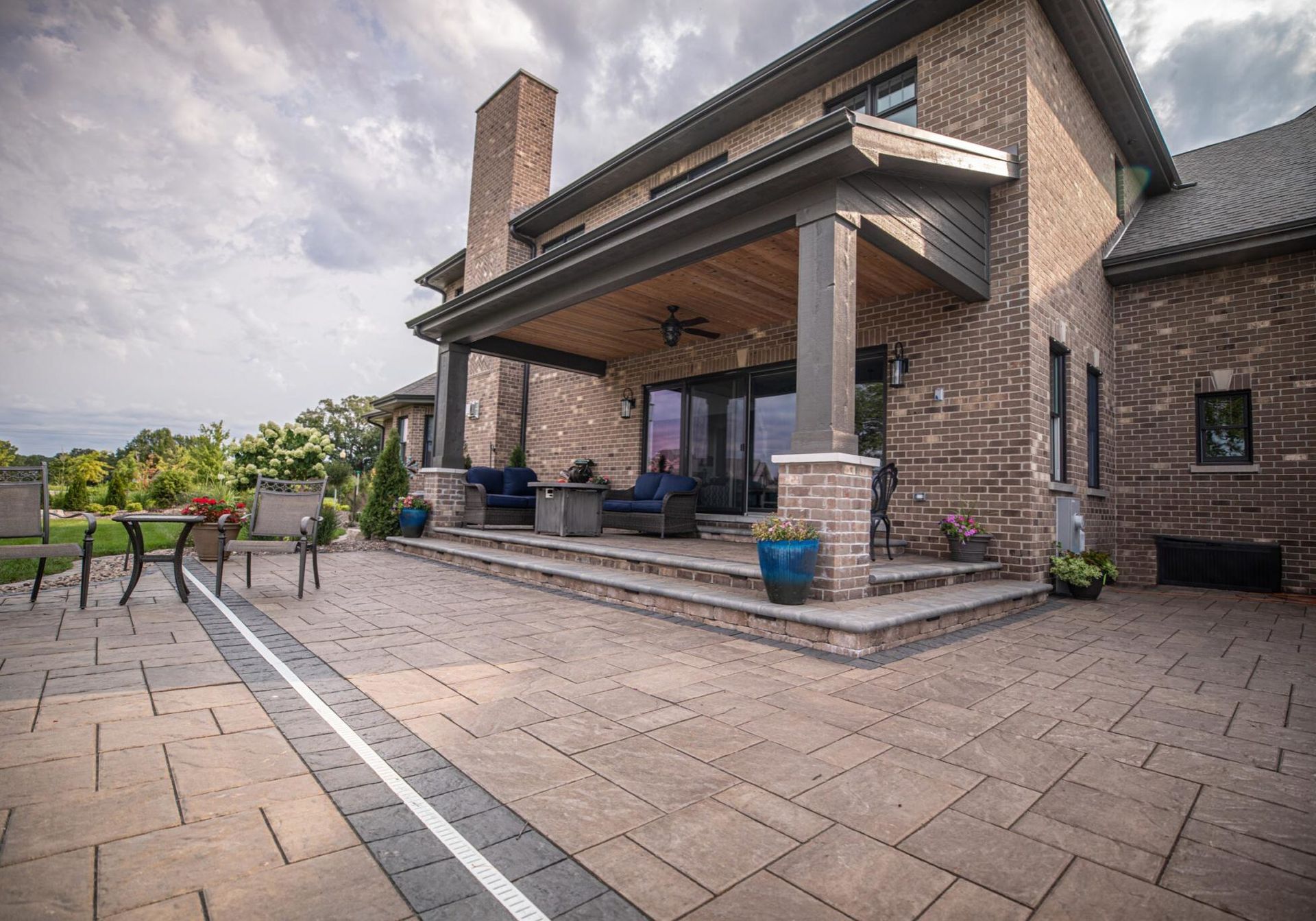 A large brick house with a large patio in front of it.