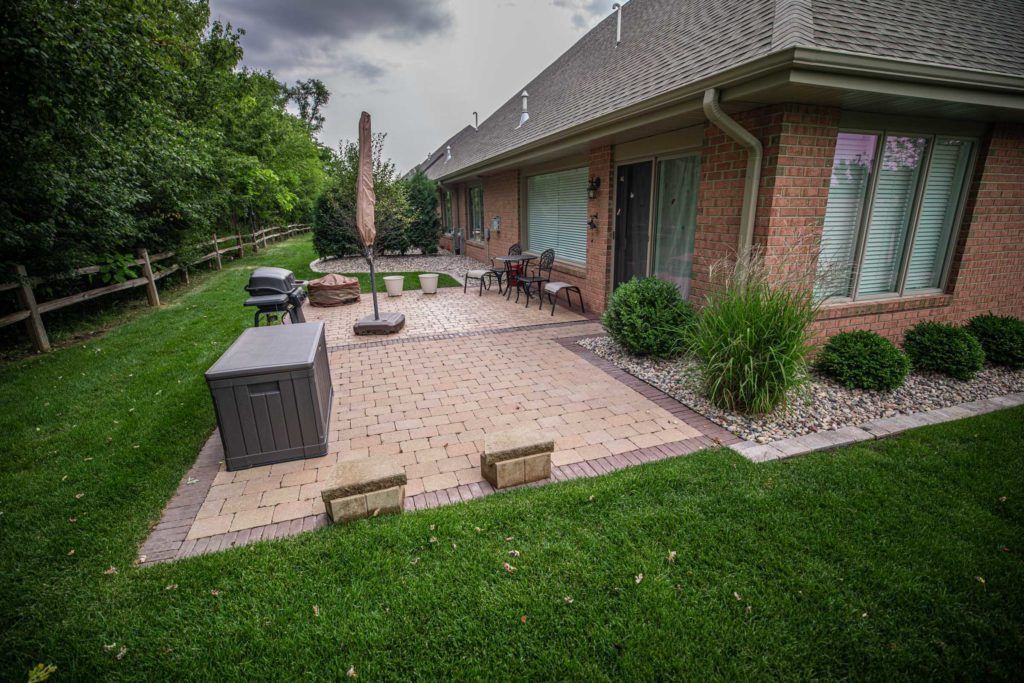A large brick house with a large patio in front of it.