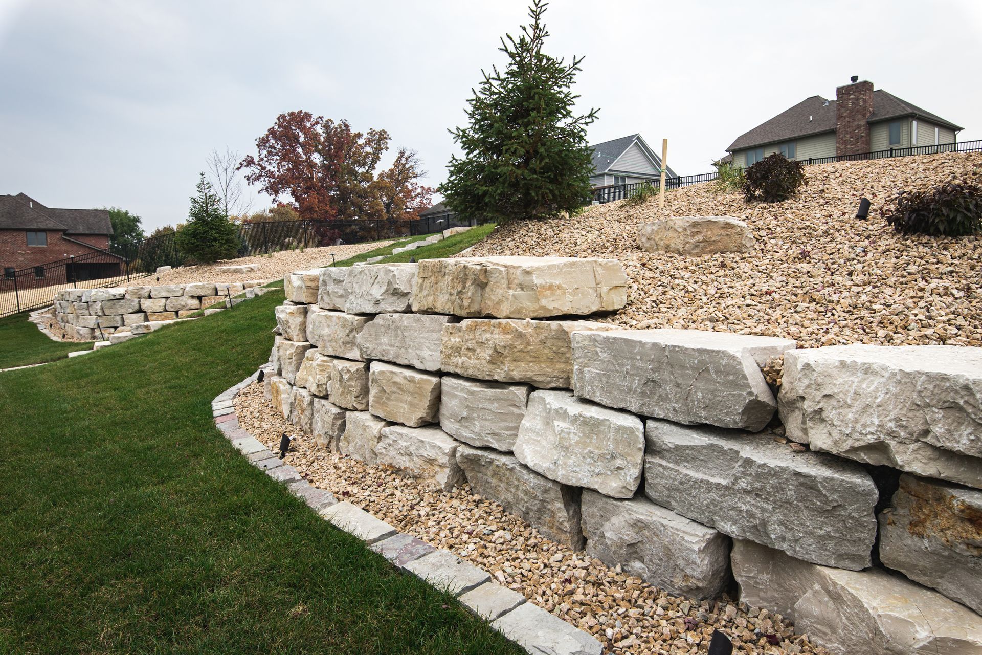 A large brick house with a large driveway in front of it.