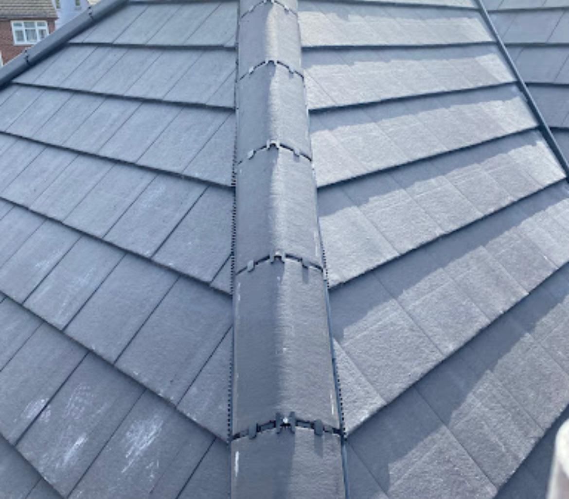 Dark gray tiled roof with a vertical ridge, viewed from above.