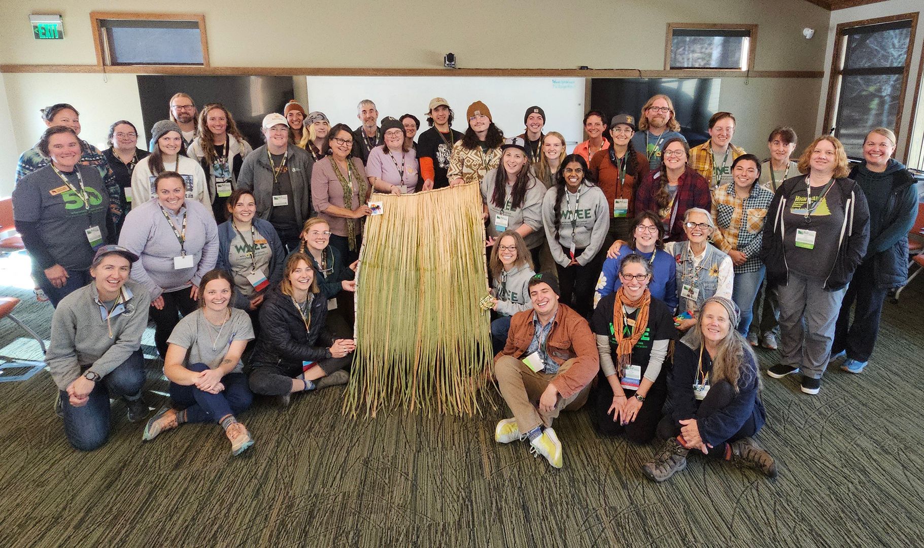 Group of conference attendees holding a cattail weaving they made