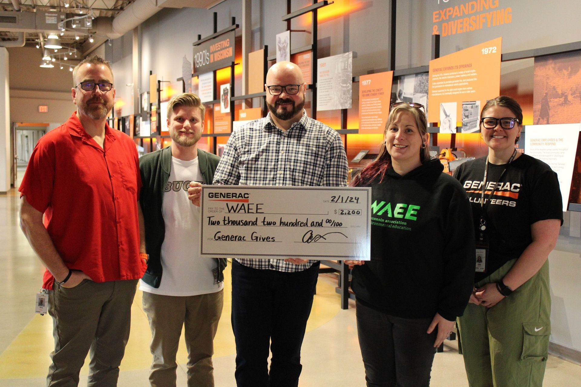 Group standing with a large check made out to WAEE