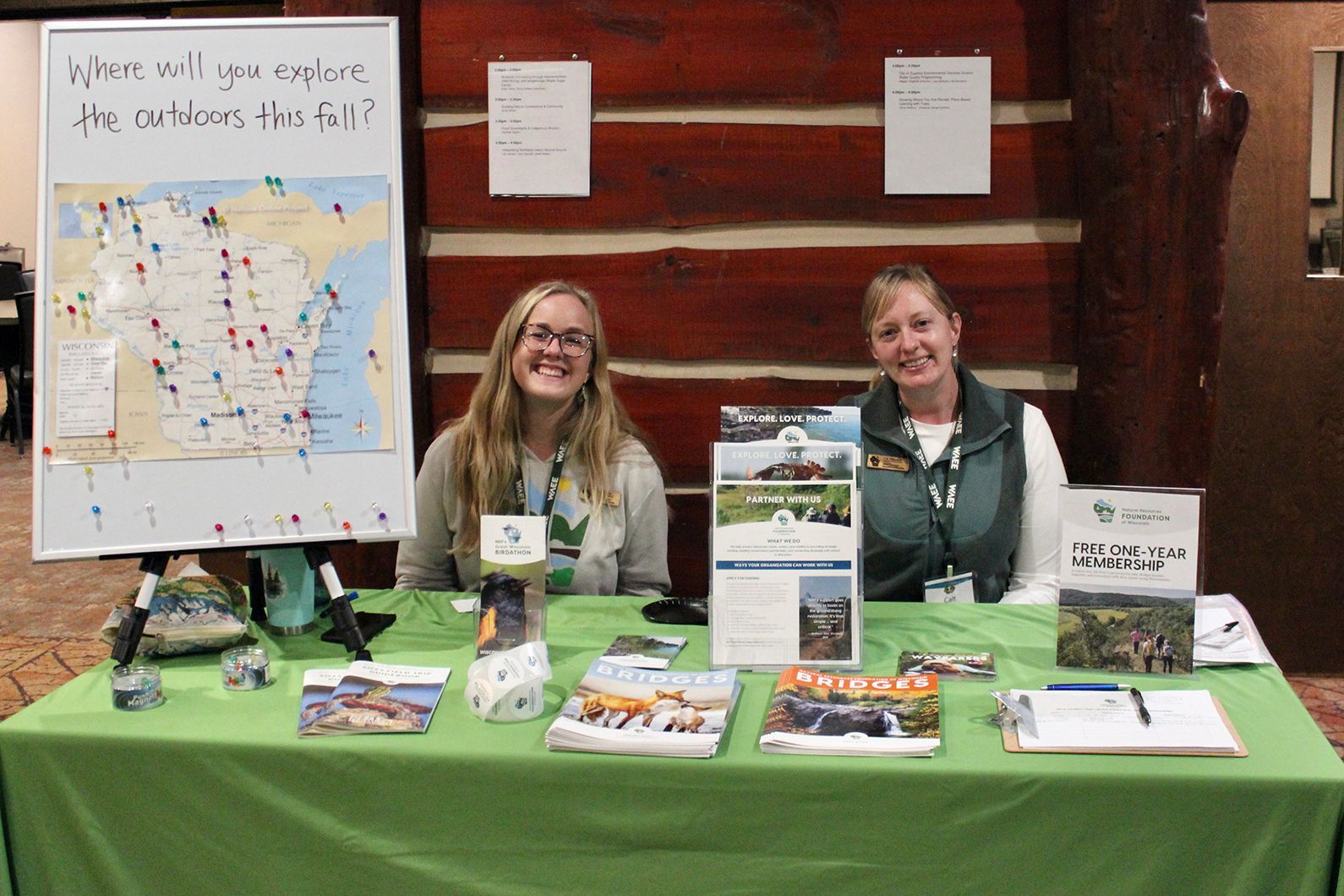 Two women sitting at an exhibit table 