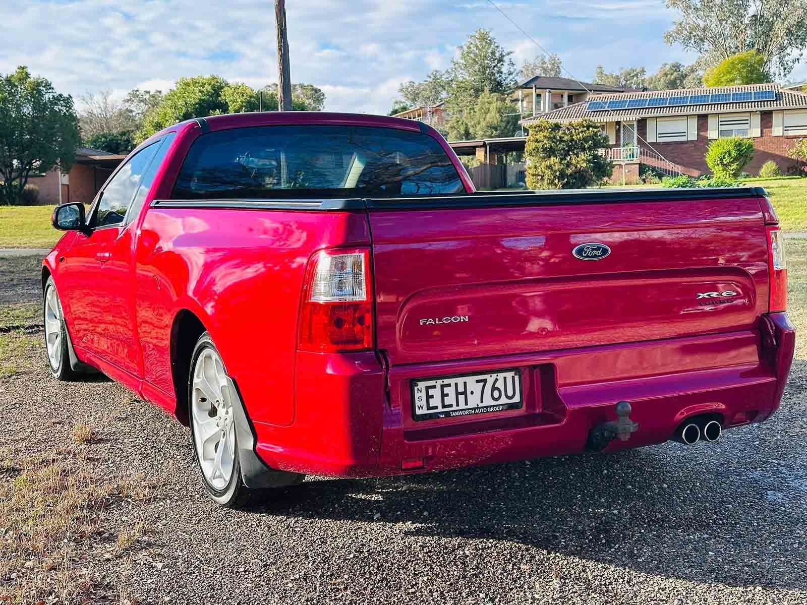 A Red Pickup Truck Is Parked In A Gravel Lot In Front Of A House — Brody’s Car Detailing In Oxley Vale, NSW