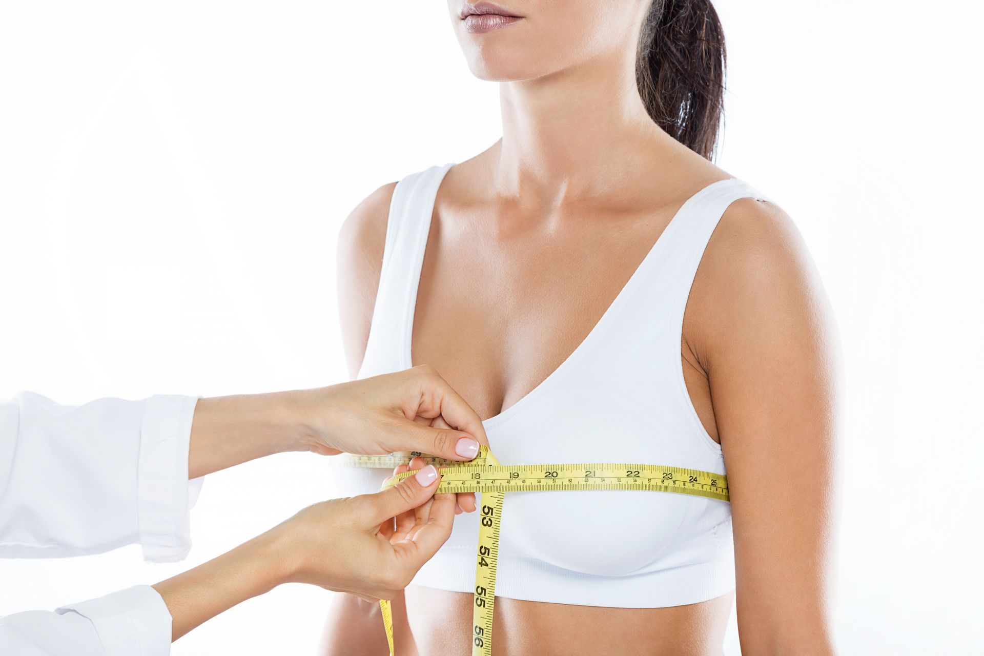 A person's chest is being measured with a yellow tape measure, white background.
