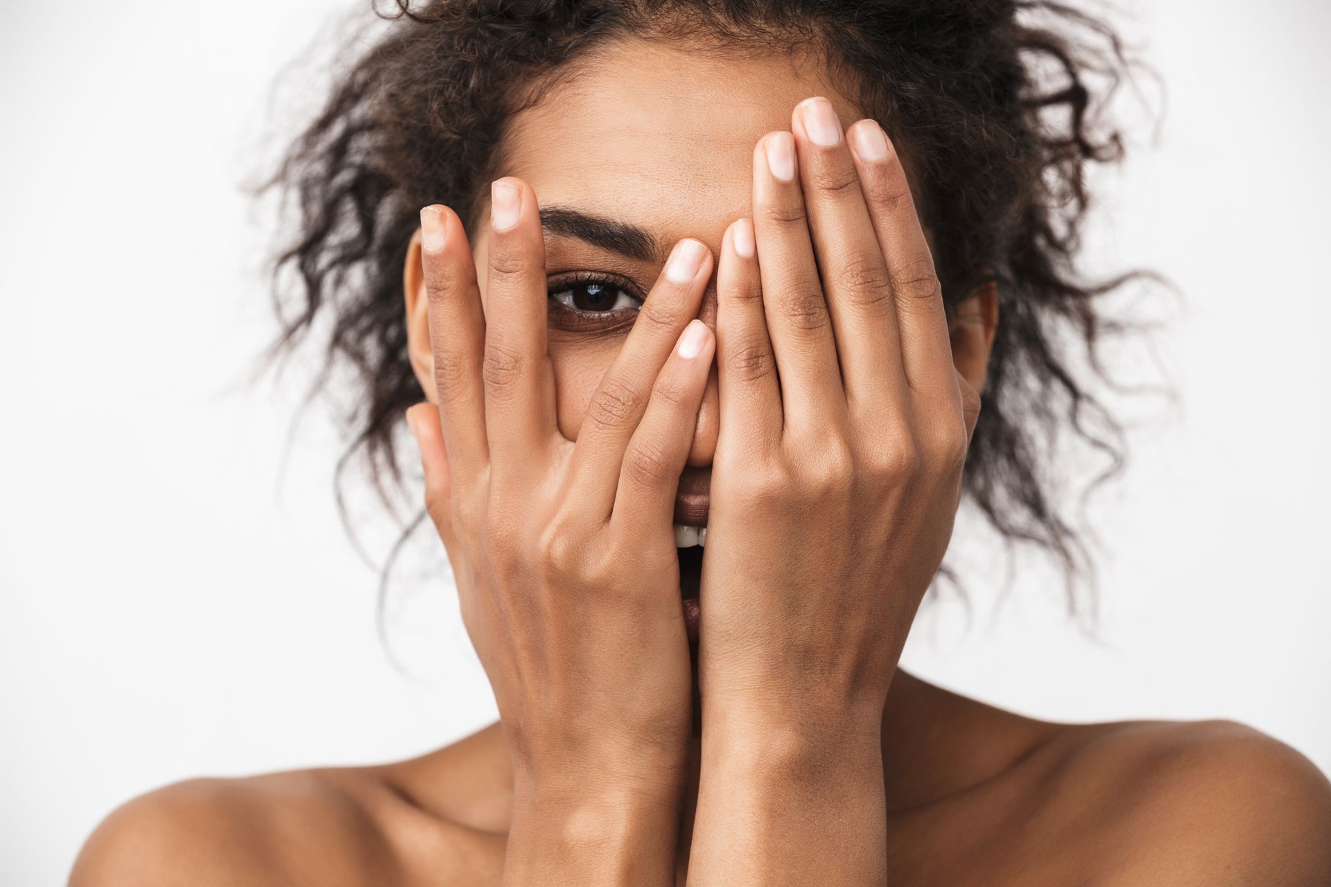 a woman is covering her face with her hands .