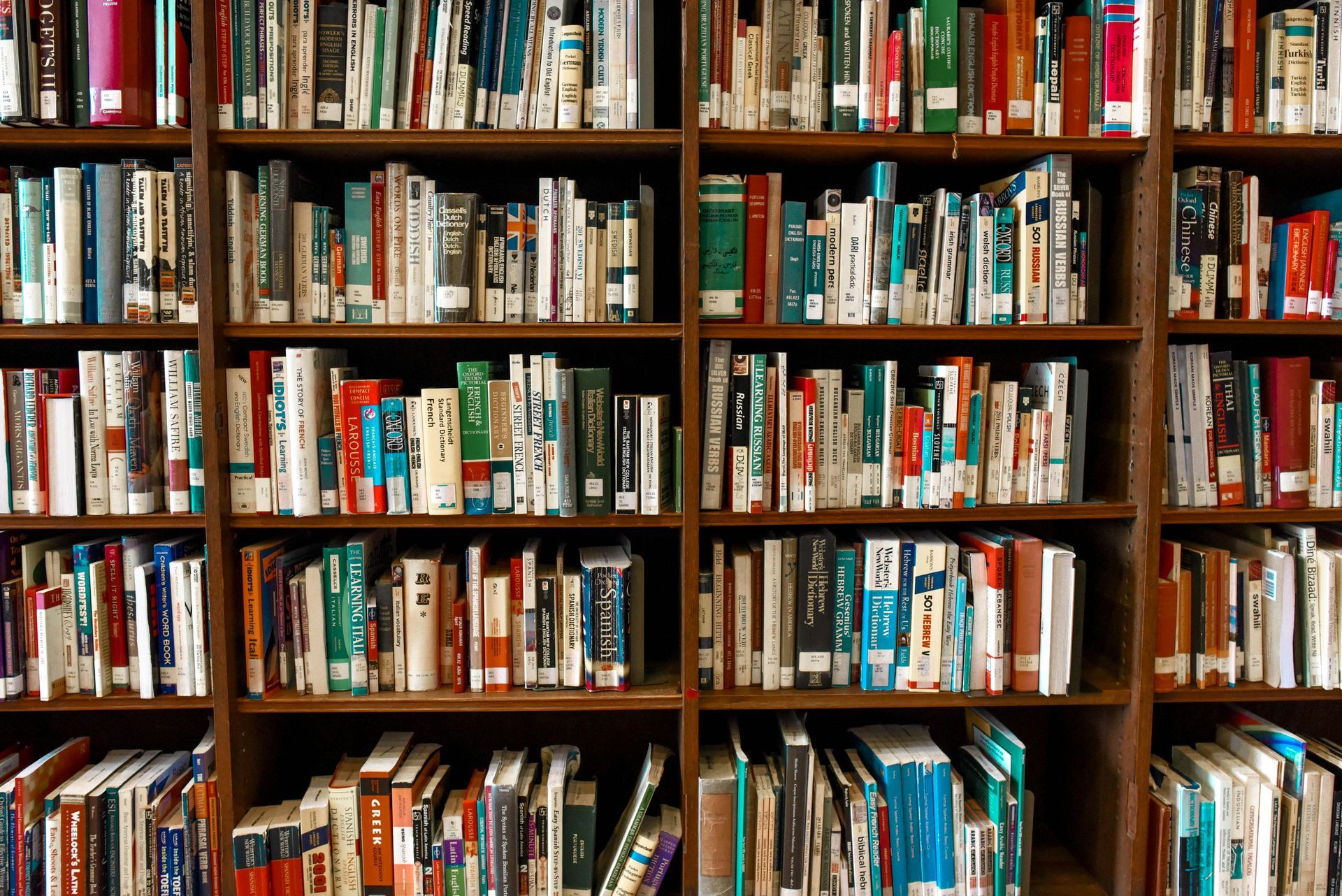 Wooden bookshelf filled with various colorful books.