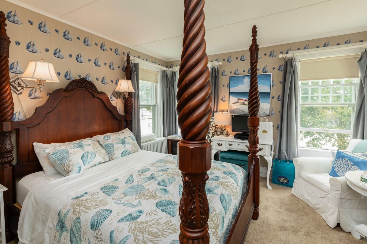 A bedroom with a four poster bed and a chair