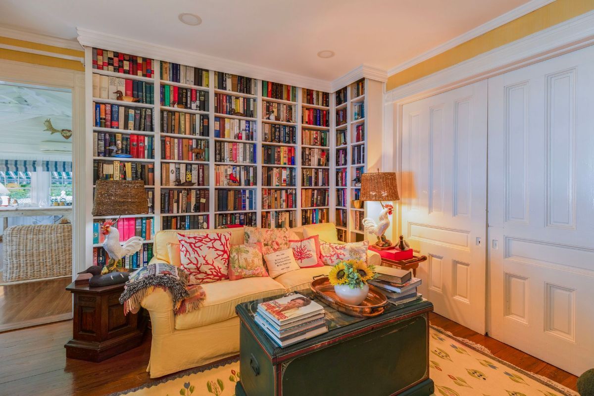A living room with a couch , coffee table , and bookshelves.