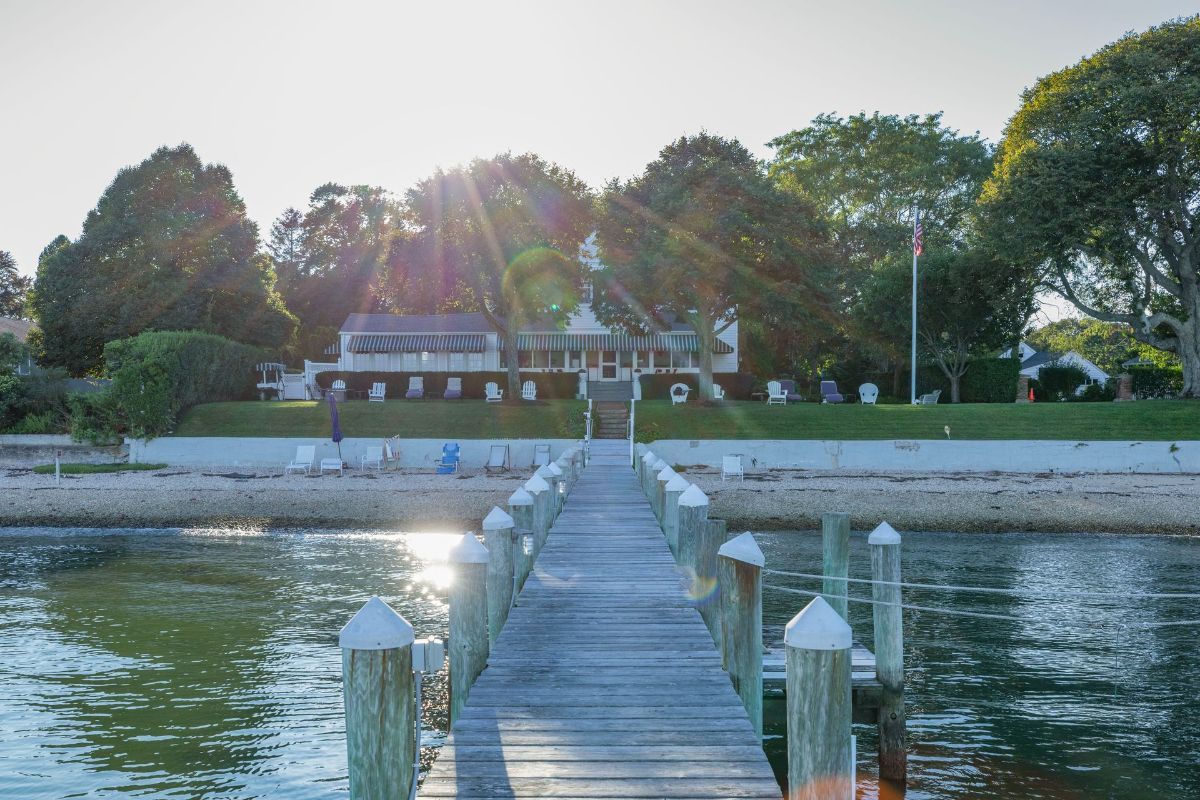 A wooden dock with a house in the background