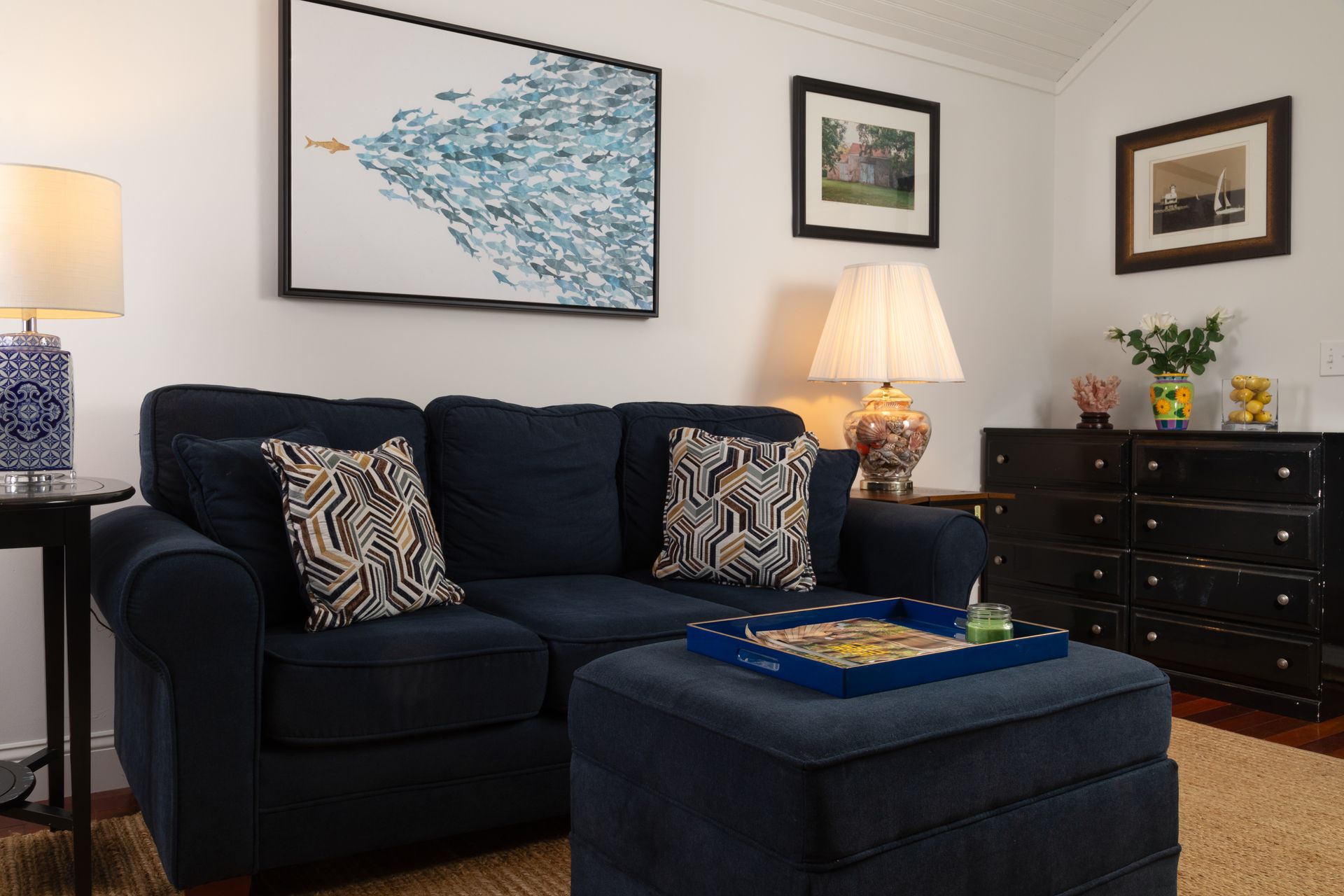 A living room with a blue couch and a blue ottoman