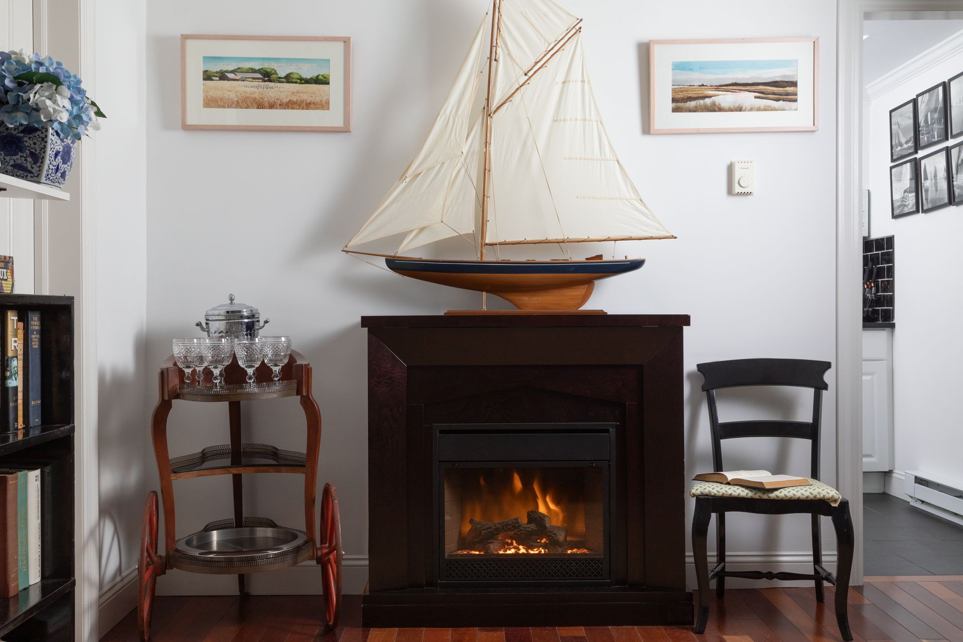 A living room with a fireplace and a sailboat on top of it