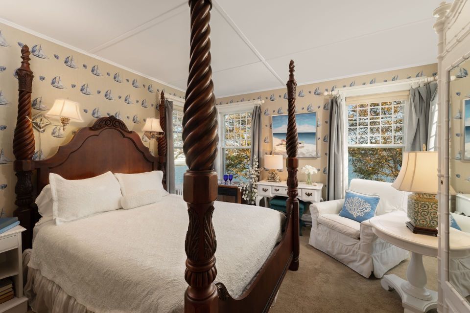 A bedroom with a four poster bed and a chair