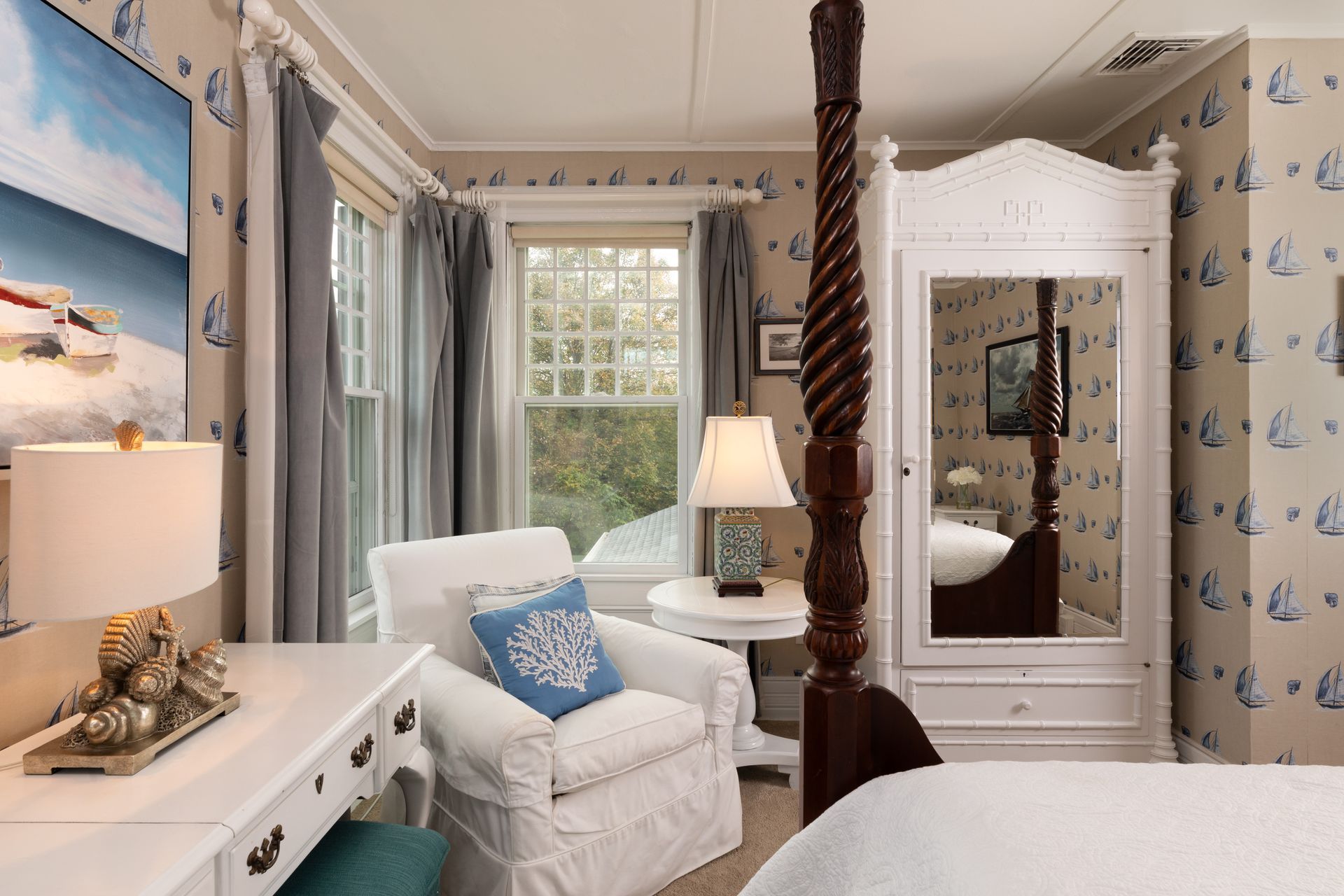 A bedroom with a four poster bed and a chair