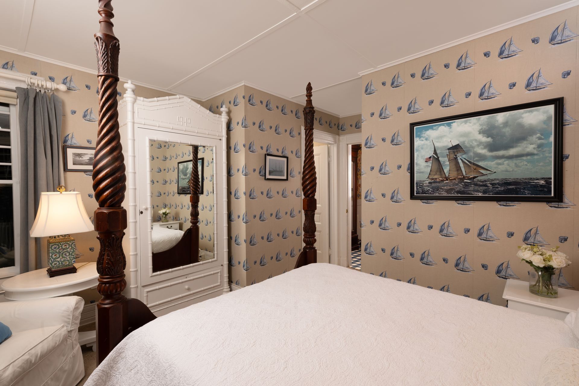 A bedroom with a four poster bed and a painting on the wall