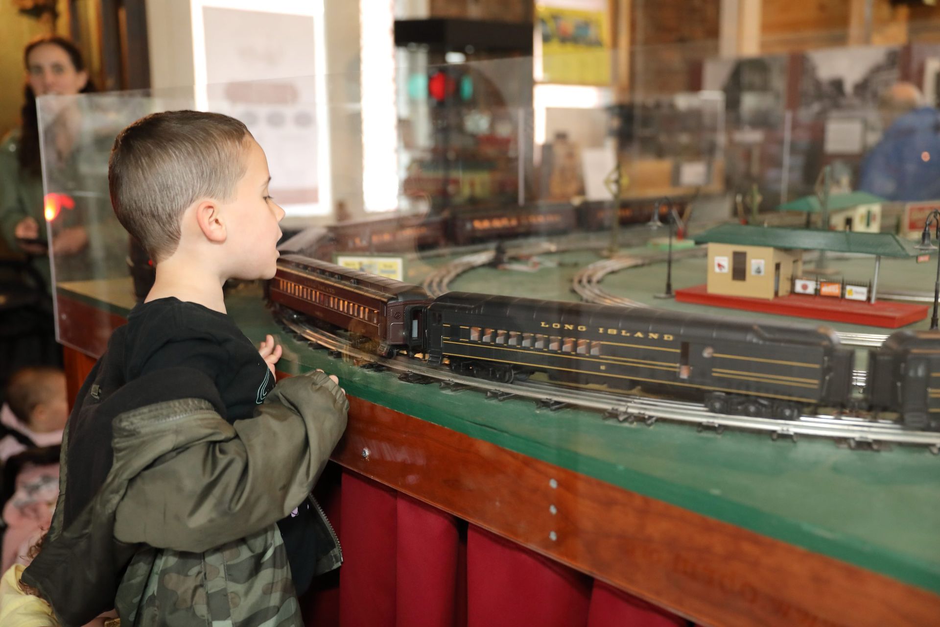 A young boy is looking at a model train set.