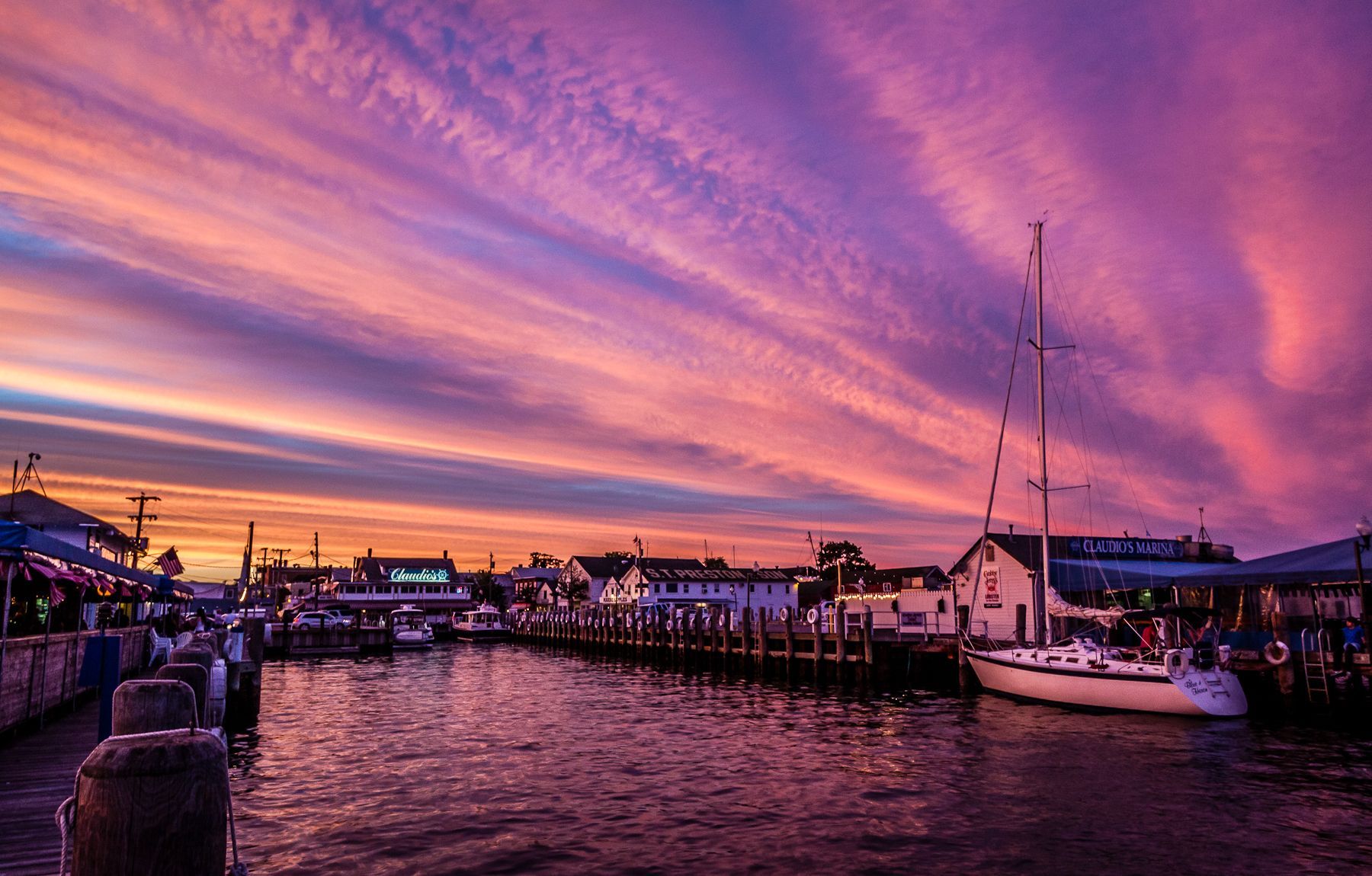 A sunset over a harbor with boats docked in the water.