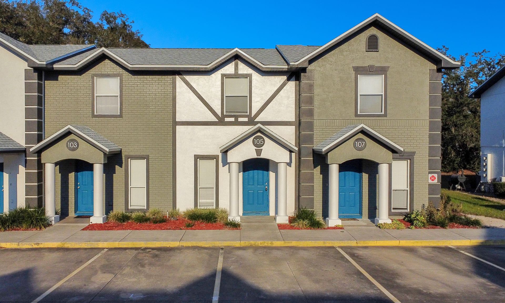 A large apartment building with a parking lot in front of it.