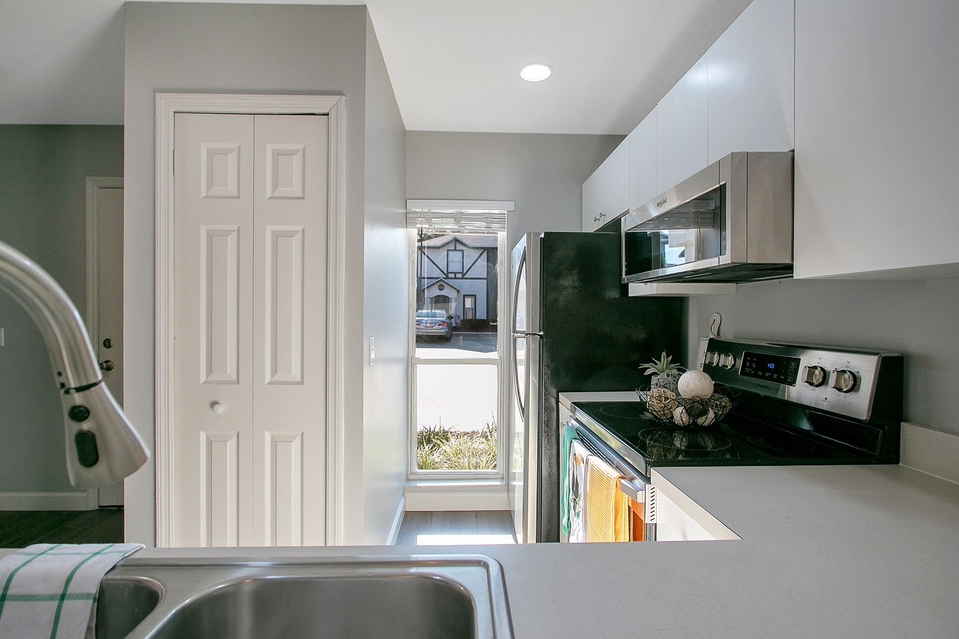 A kitchen with a sink , stove and refrigerator.