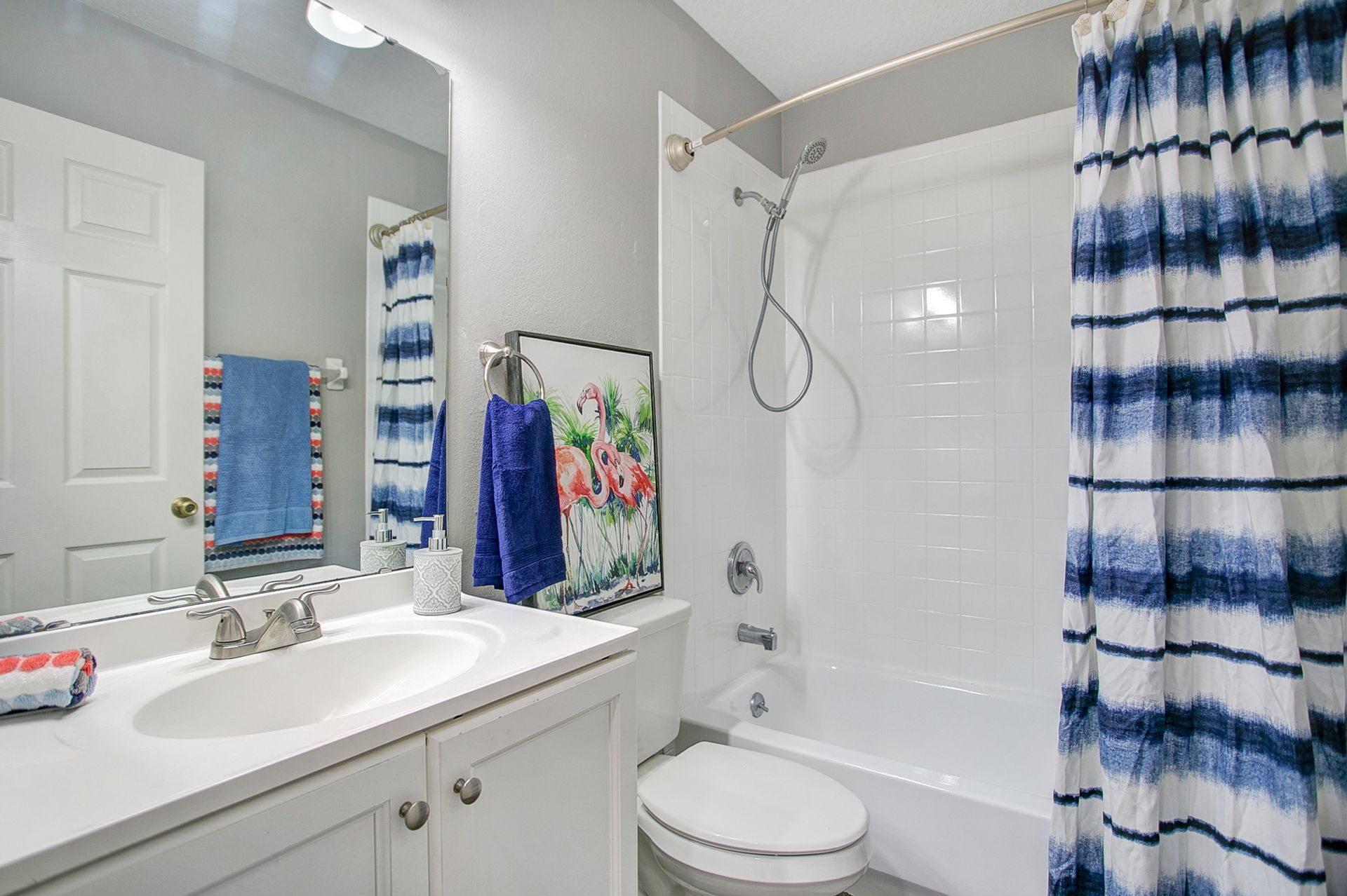 A bathroom with a sink , toilet , bathtub and shower curtain.