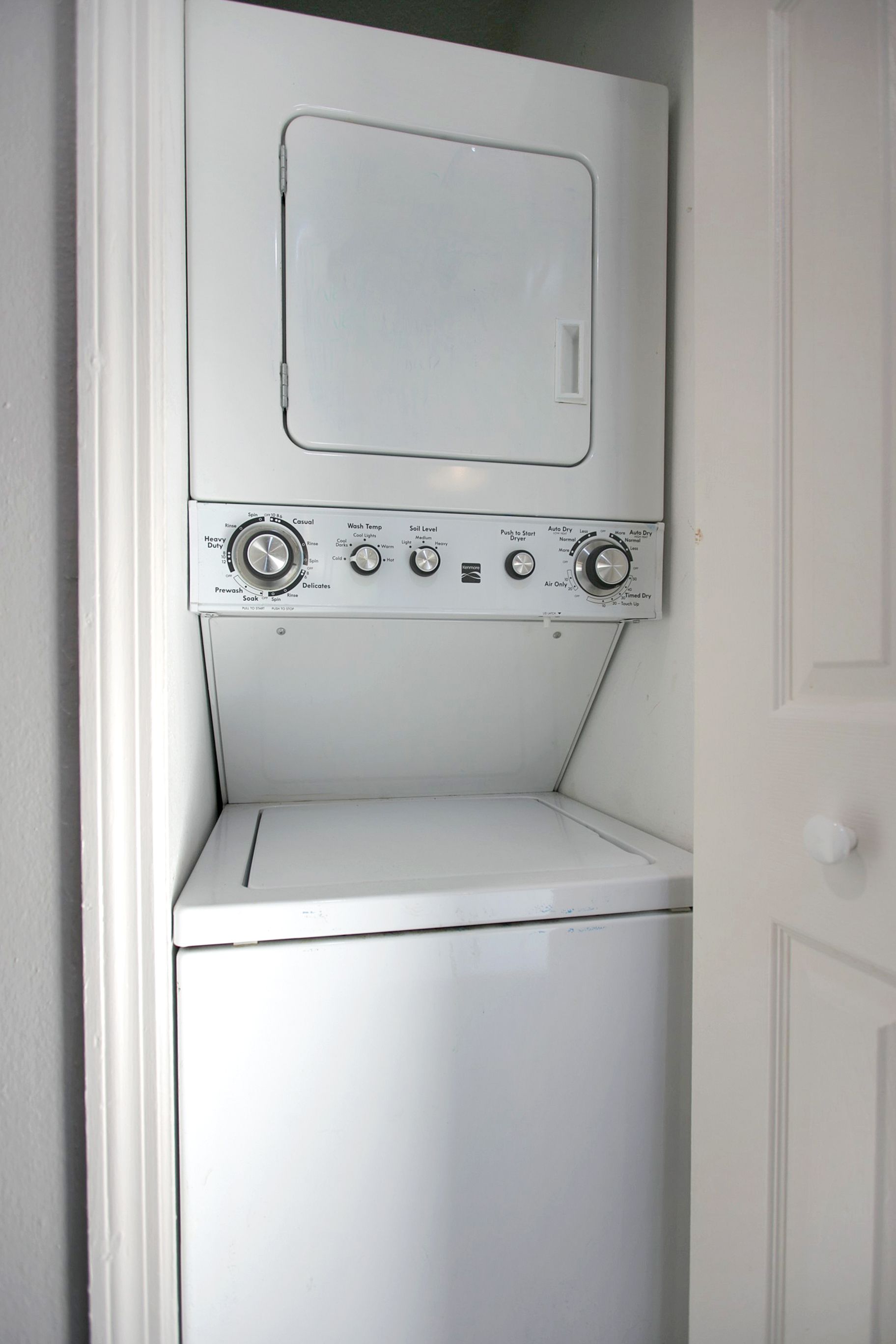 A washer and dryer are stacked on top of each other in a closet.
