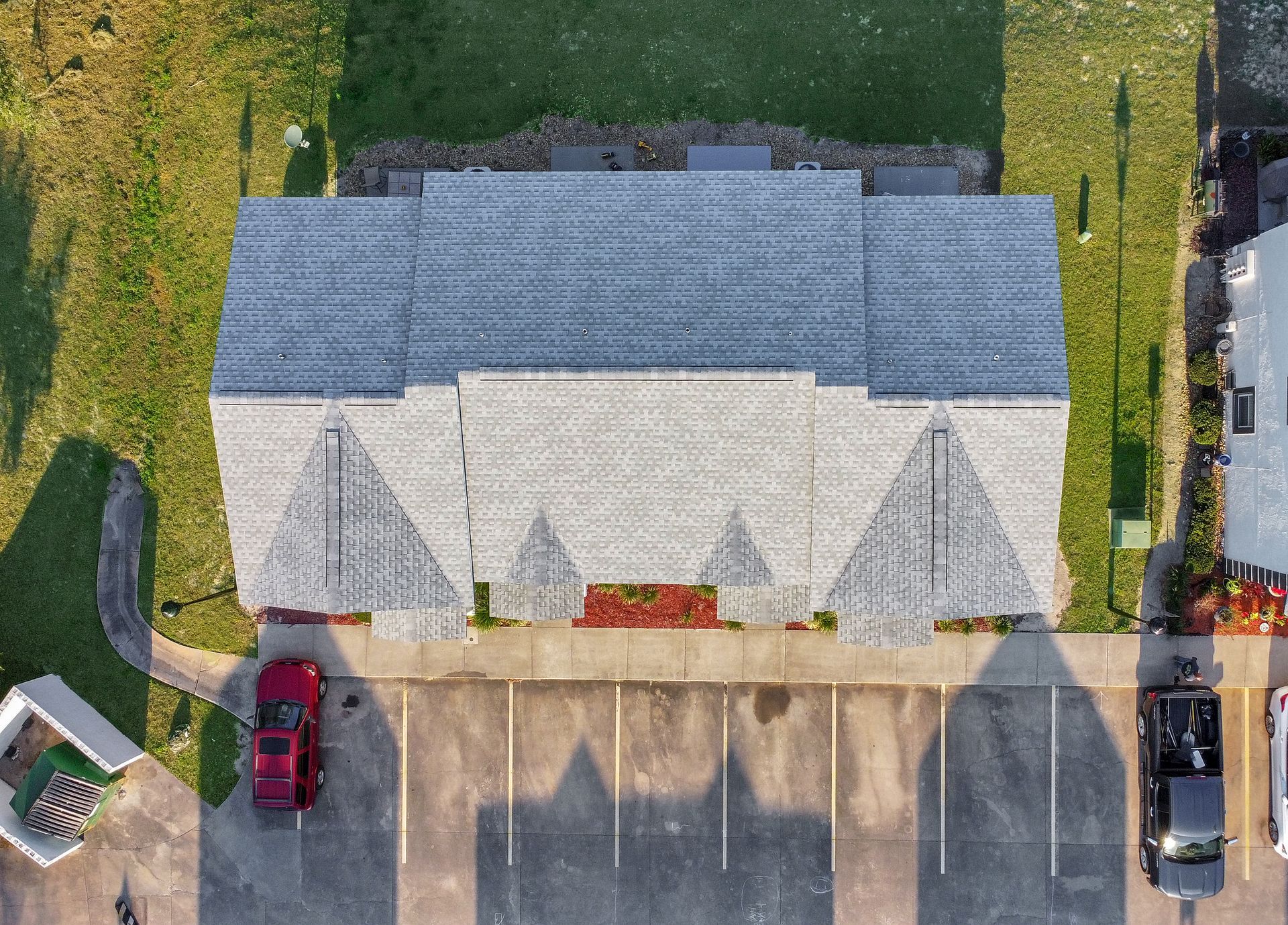 An aerial view of a apartment building with a red truck parked in front of it.