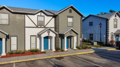 A group of houses are sitting next to each other in a parking lot.